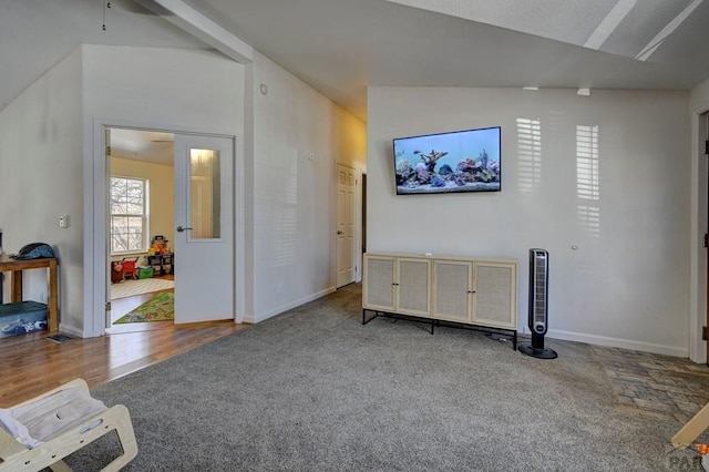 carpeted living area with vaulted ceiling and baseboards