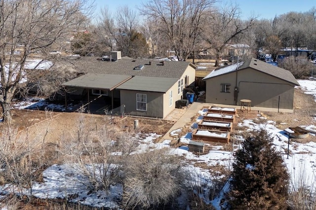 snow covered property featuring stucco siding