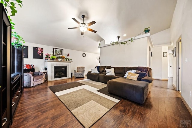 living room with vaulted ceiling, dark wood-type flooring, and a tile fireplace