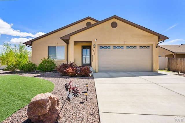 ranch-style house featuring a garage, driveway, fence, and stucco siding