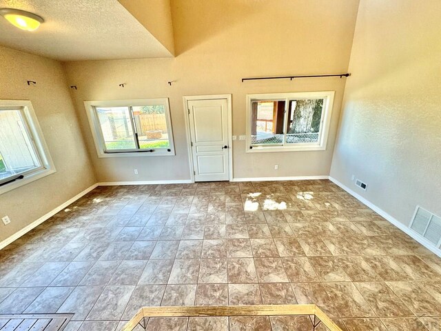 interior space with visible vents, a textured ceiling, and baseboards