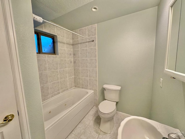 bathroom with baseboards, toilet, shower / tub combination, tile patterned flooring, and a textured ceiling