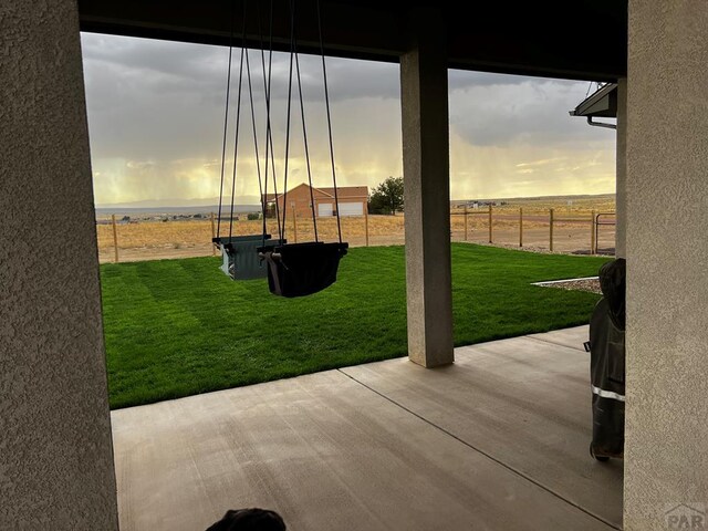 yard at dusk featuring a patio area and fence