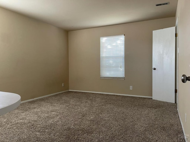 carpeted spare room with baseboards and visible vents