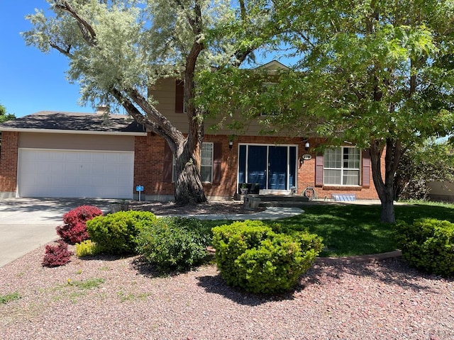 view of front of property featuring an attached garage, concrete driveway, and brick siding