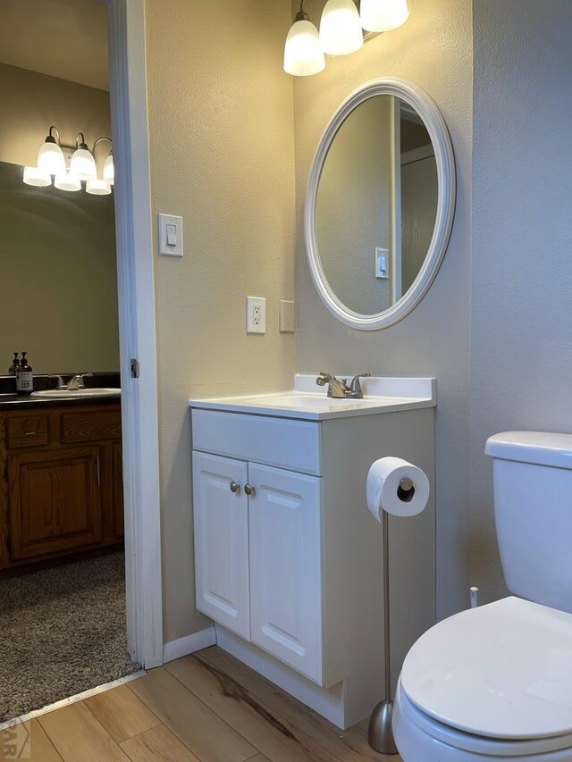 bathroom featuring vanity, wood finished floors, and toilet