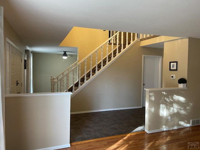 stairs with ceiling fan, wood finished floors, visible vents, and baseboards