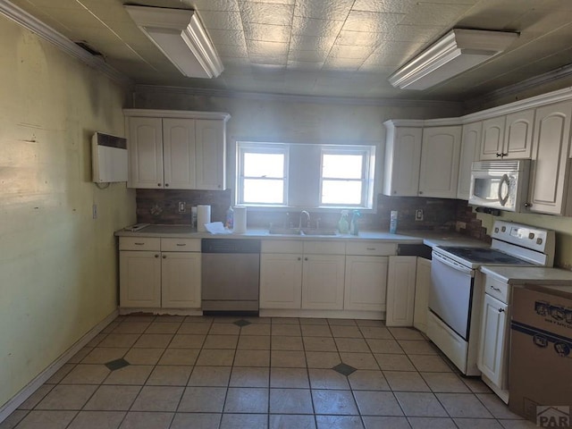 kitchen featuring light countertops, white appliances, a sink, and white cabinetry