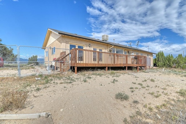 rear view of property with fence and a wooden deck