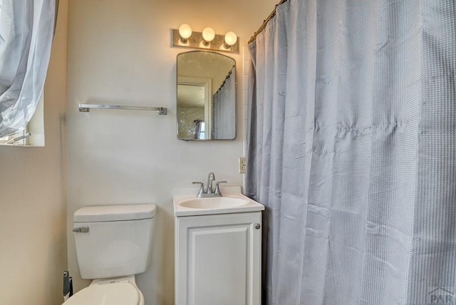 full bathroom with toilet and vanity