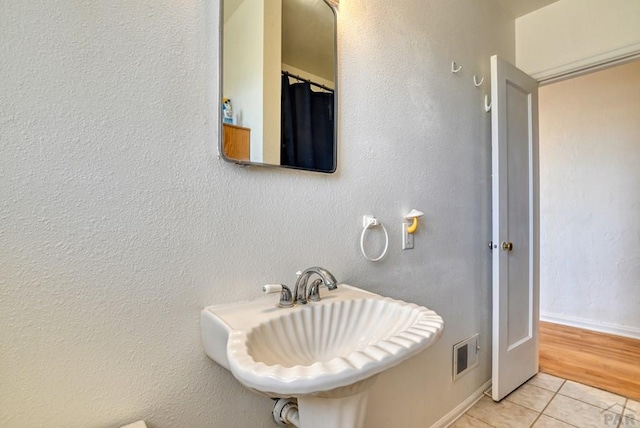 bathroom with a sink, tile patterned flooring, and visible vents