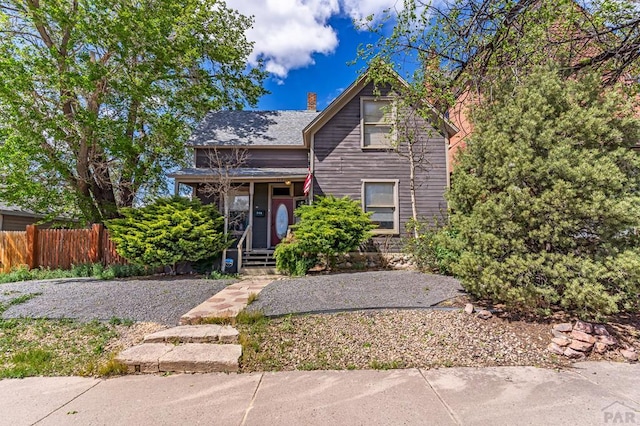 view of front of home featuring a chimney and fence