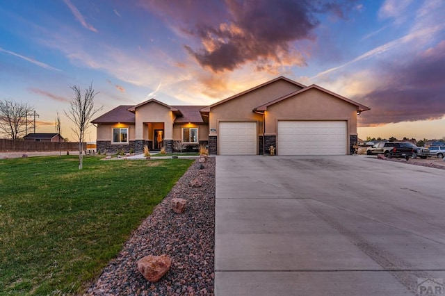 view of front of house with a front yard, an attached garage, stone siding, stucco siding, and driveway