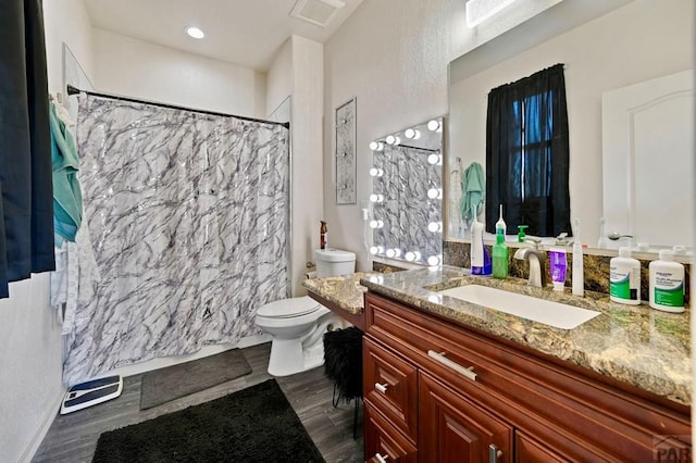 full bath featuring visible vents, a shower with shower curtain, toilet, vanity, and wood finished floors