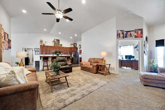 living area featuring light carpet, recessed lighting, visible vents, ceiling fan, and high vaulted ceiling