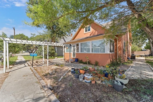 view of front facade featuring a pergola and stucco siding