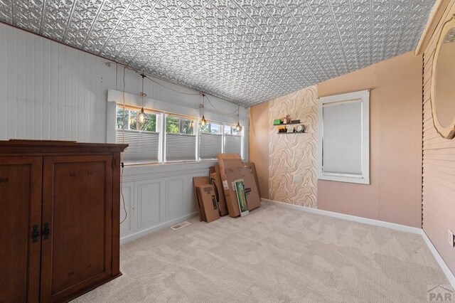 carpeted empty room featuring an ornate ceiling, visible vents, and baseboards