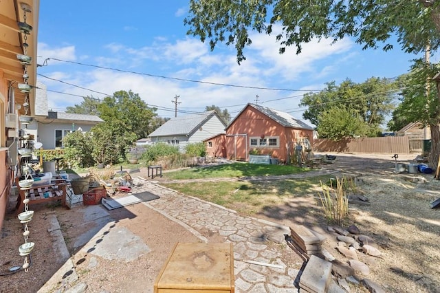 view of yard with fence and an outbuilding