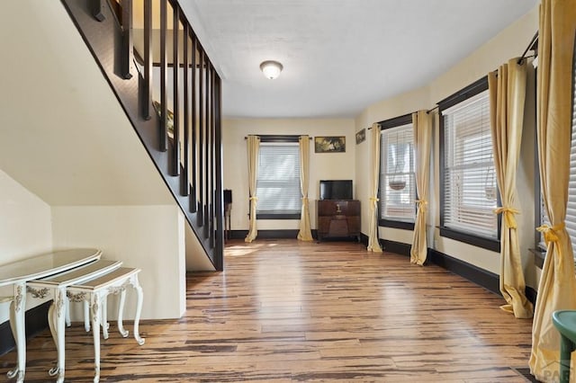 entryway with hardwood / wood-style floors, stairway, and baseboards