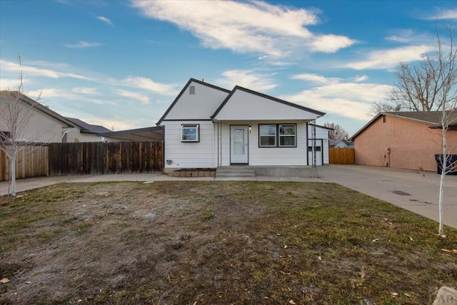 bungalow-style home with a front yard and fence