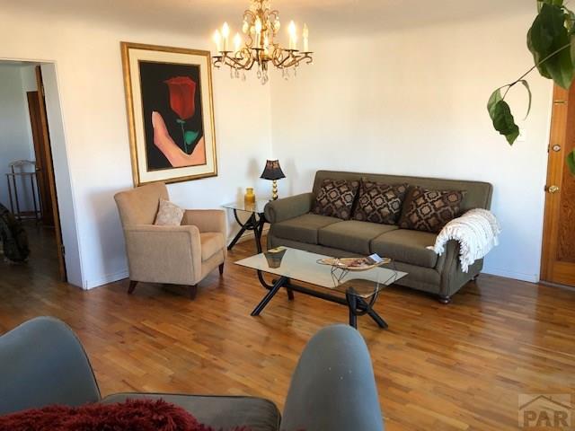 230 W First St, Trinidad, CO 81082 - living area featuring wood finished floors and a chandelier