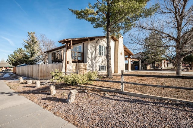 view of front of house with a chimney and fence