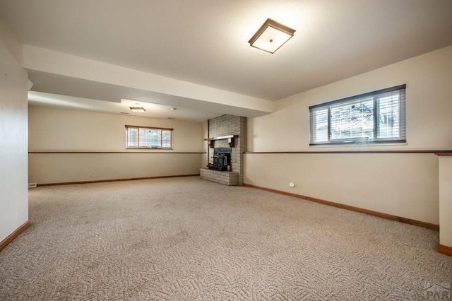 unfurnished living room with carpet flooring, a fireplace, and baseboards