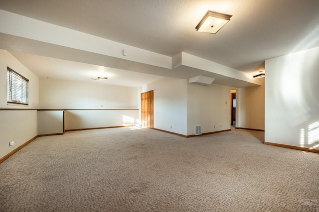 unfurnished room featuring carpet flooring, visible vents, and baseboards