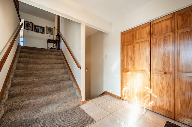 stairway with baseboards and tile patterned floors