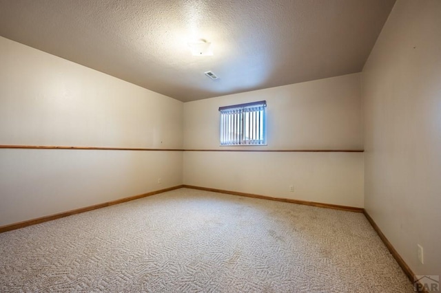 additional living space featuring carpet, visible vents, a textured ceiling, and baseboards