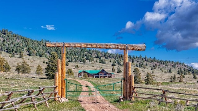 view of yard with a gate, fence, and a rural view