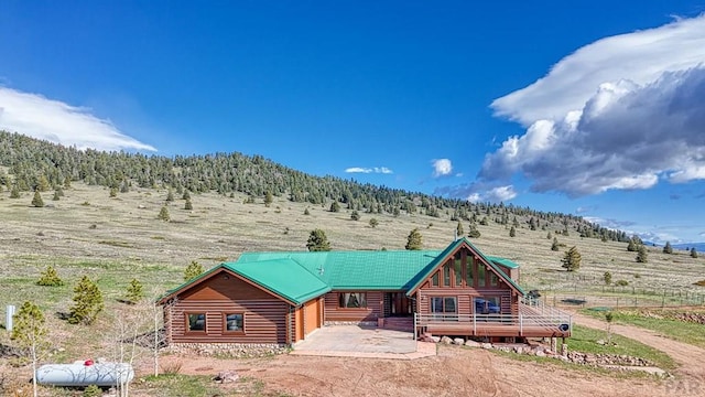 log home with driveway, log siding, a mountain view, and a rural view