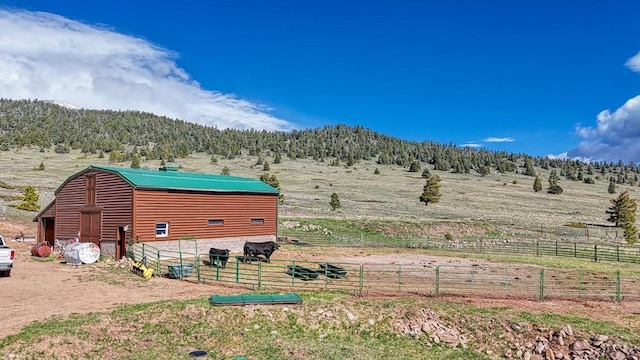 exterior space featuring an exterior structure, a rural view, an outdoor structure, and a mountain view