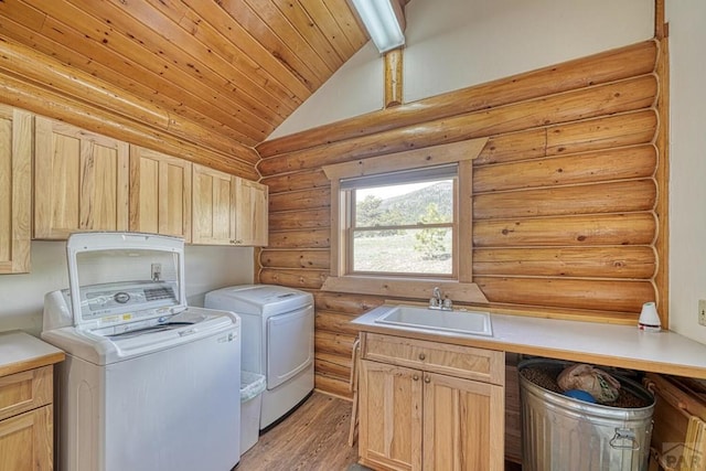 laundry area featuring separate washer and dryer, a sink, wood ceiling, light wood-type flooring, and cabinet space