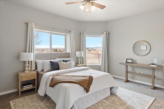 bedroom featuring light colored carpet, baseboards, and ceiling fan