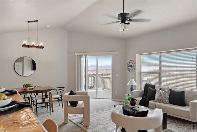 living area with baseboards, lofted ceiling, light colored carpet, and ceiling fan with notable chandelier