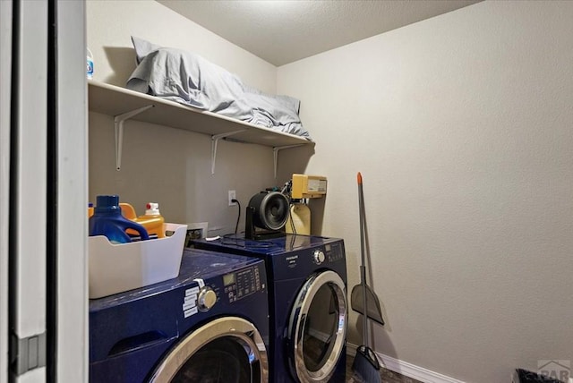 clothes washing area featuring laundry area, baseboards, and separate washer and dryer