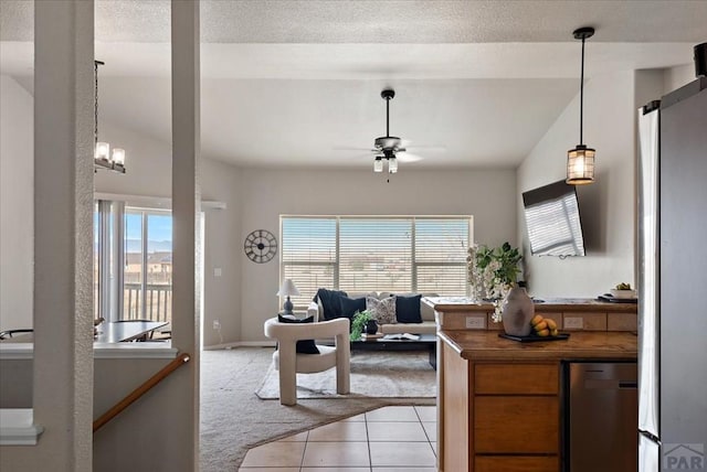 living room with a ceiling fan, a textured ceiling, light tile patterned floors, lofted ceiling, and light colored carpet