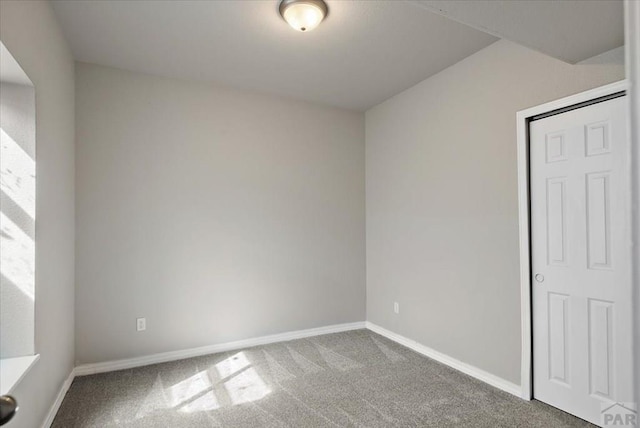 carpeted empty room with baseboards