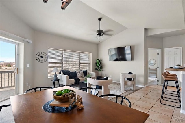 dining area with lofted ceiling, light tile patterned floors, baseboards, and ceiling fan