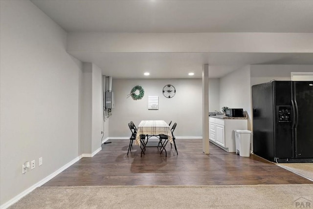 carpeted dining room featuring recessed lighting, baseboards, wood finished floors, and water heater