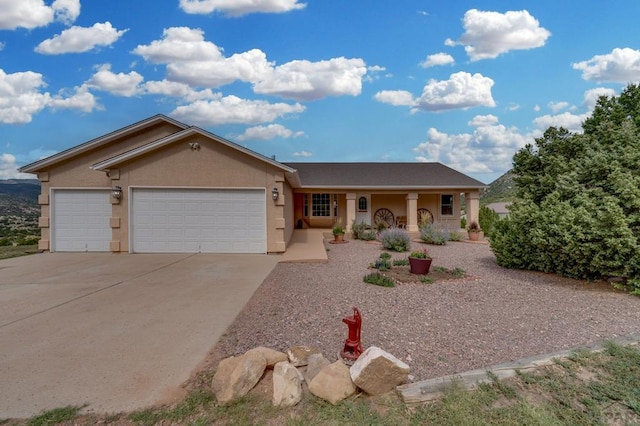 ranch-style home with a garage, concrete driveway, and stucco siding