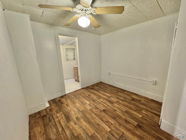 empty room with wood finished floors and a ceiling fan