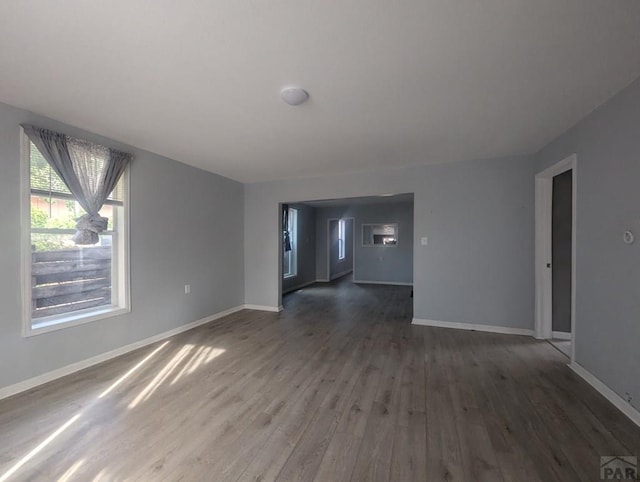 spare room with dark wood-style floors and baseboards