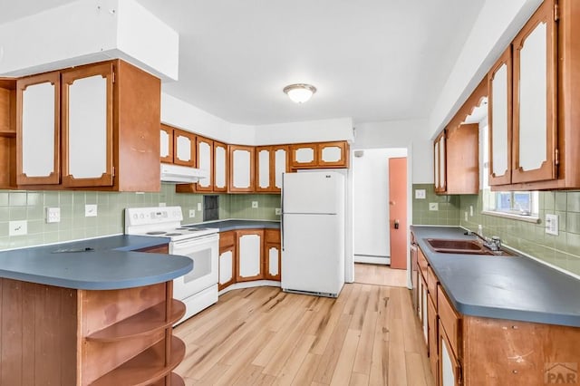 kitchen featuring open shelves, a sink, a baseboard heating unit, white appliances, and backsplash
