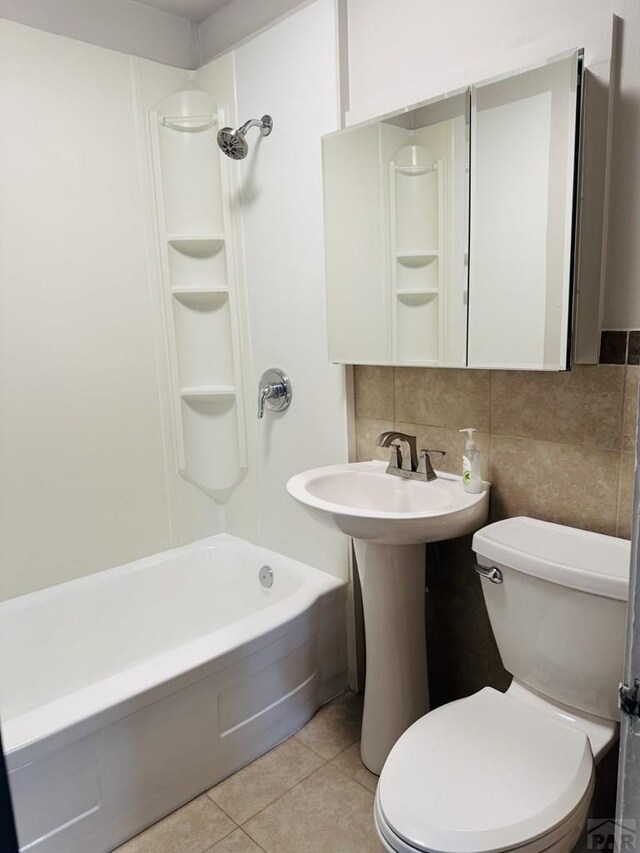 full bathroom featuring tile patterned floors, toilet, a sink, backsplash, and shower / bathtub combination