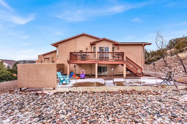 rear view of house with a patio area, stairway, a deck, and stucco siding