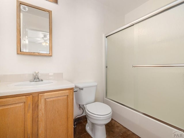 4400 Rawhide Rd Unit 132, Pueblo, CO 81008 - bathroom with bath / shower combo with glass door, toilet, a ceiling fan, tile patterned flooring, and vanity