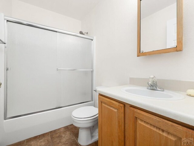 4400 Rawhide Rd Unit 132, Pueblo, CO 81008 - bathroom with enclosed tub / shower combo, toilet, vanity, and tile patterned floors