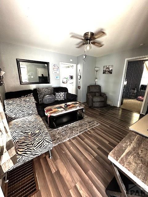 living room with a ceiling fan and dark wood finished floors